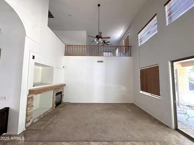 33506 N 24th Dr, Phoenix, AZ 85085 - unfurnished living room featuring a high ceiling, carpet flooring, ceiling fan, arched walkways, and a stone fireplace