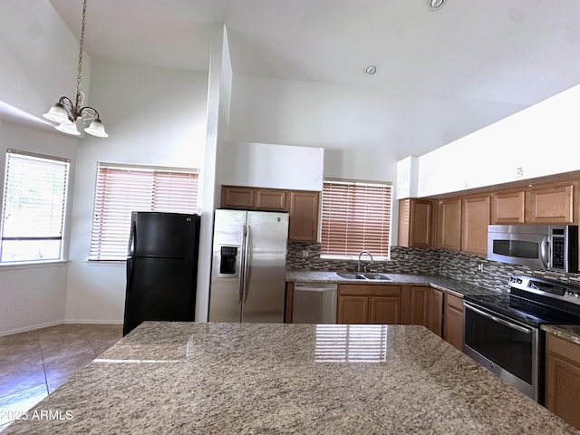 33506 N 24th Dr, Phoenix, AZ 85085 - kitchen featuring stainless steel appliances, a sink, a chandelier, light stone countertops, and decorative backsplash