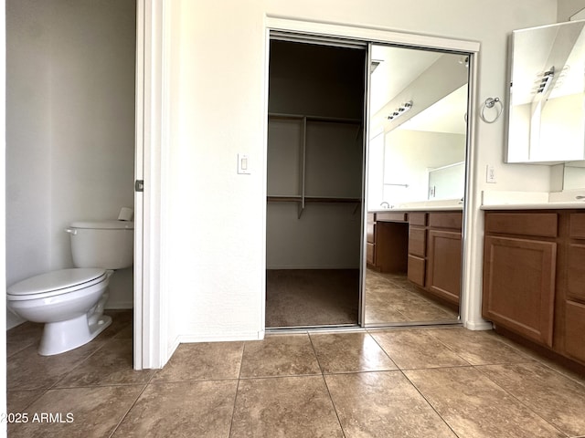 33506 N 24th Dr, Phoenix, AZ 85085 - bathroom with vanity, toilet, a spacious closet, and tile patterned floors