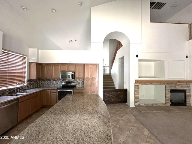 33506 N 24th Dr, Phoenix, AZ 85085 - kitchen featuring stainless steel appliances, a towering ceiling, light tile patterned floors, a sink, and light stone counters