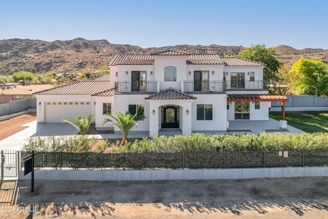 mediterranean / spanish home with a balcony, a garage, and a mountain view