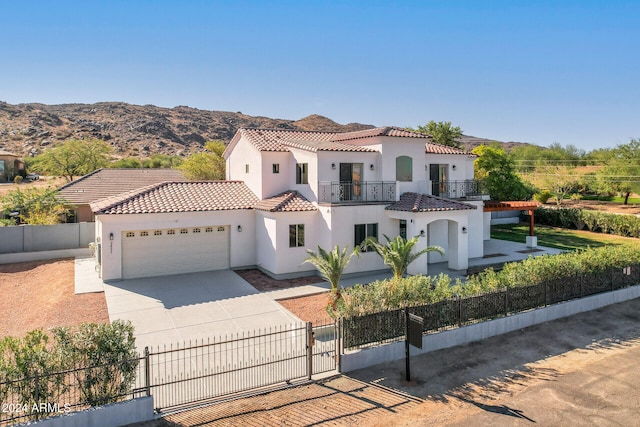 mediterranean / spanish-style home featuring a balcony, a garage, and a mountain view