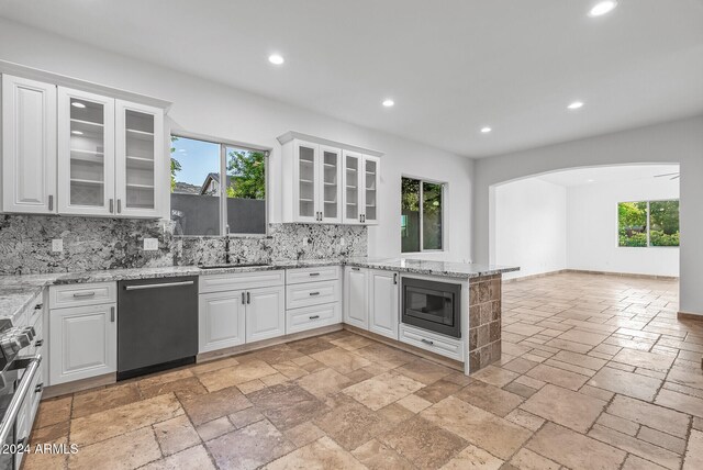 kitchen with white cabinetry, black appliances, plenty of natural light, and decorative backsplash