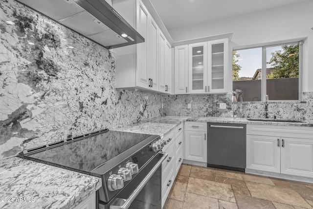 kitchen featuring light stone countertops, tasteful backsplash, appliances with stainless steel finishes, and white cabinets