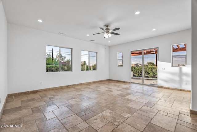 unfurnished room with ceiling fan and plenty of natural light