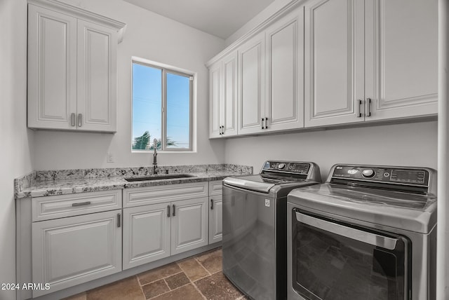 laundry area with sink, washer and dryer, and cabinets