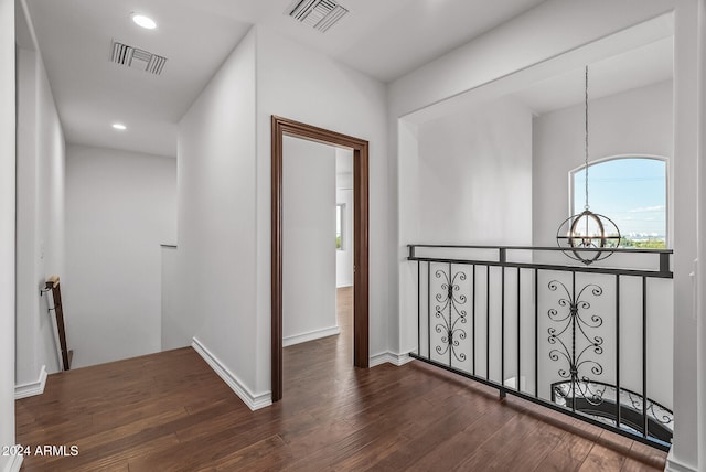 hallway with a chandelier and dark hardwood / wood-style flooring