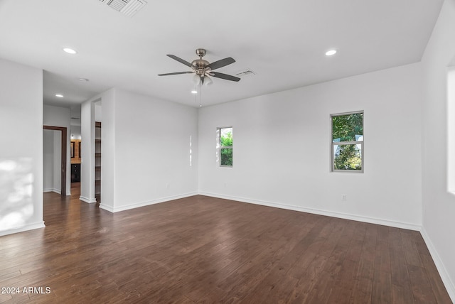 spare room featuring dark wood-type flooring, ceiling fan, and plenty of natural light