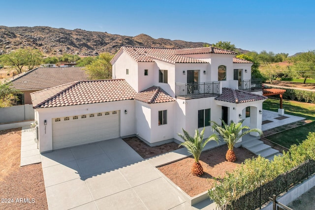 mediterranean / spanish-style home with a mountain view, a balcony, and a garage