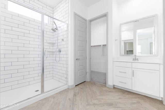 bathroom with an enclosed shower, vanity, and parquet floors