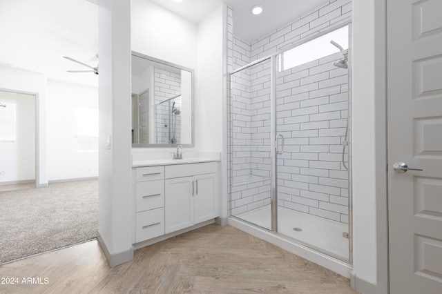 bathroom featuring an enclosed shower, vanity, and ceiling fan