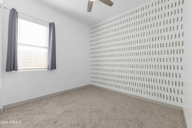 carpeted spare room featuring ceiling fan and a healthy amount of sunlight