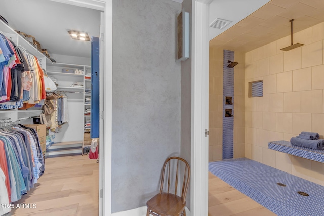 interior space with a shower and hardwood / wood-style flooring