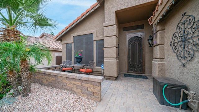 view of exterior entry with a patio area