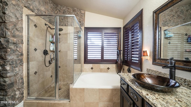 bathroom with plus walk in shower, vanity, and lofted ceiling