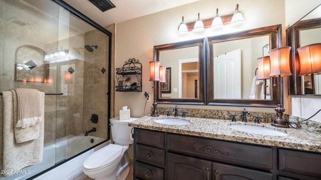 full bathroom with shower / bath combination with glass door, vanity, and toilet