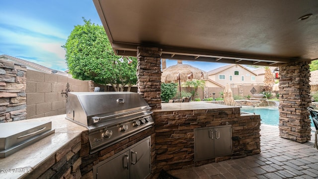 view of patio / terrace featuring a fenced in pool, a grill, pool water feature, and area for grilling