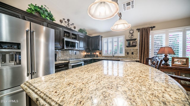 kitchen featuring decorative backsplash, stainless steel appliances, plenty of natural light, and sink