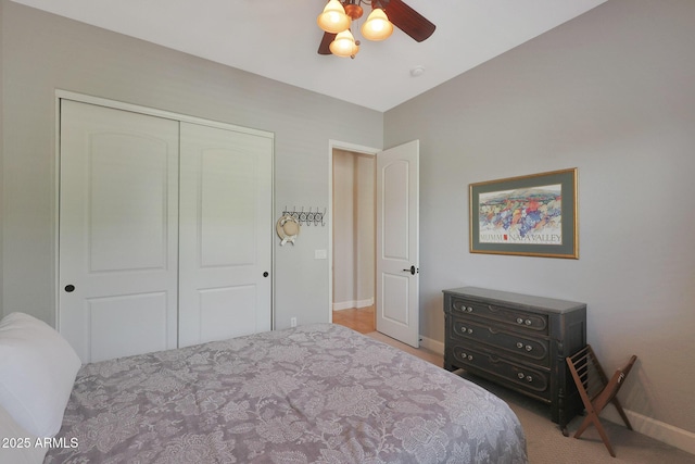 bedroom featuring carpet floors, a closet, baseboards, and a ceiling fan
