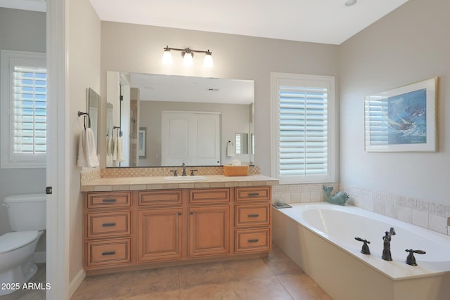 full bathroom with toilet, a bath, vanity, and tile patterned floors