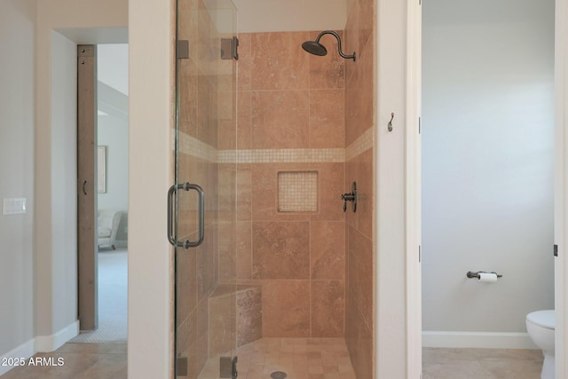 full bathroom with a stall shower, toilet, and baseboards