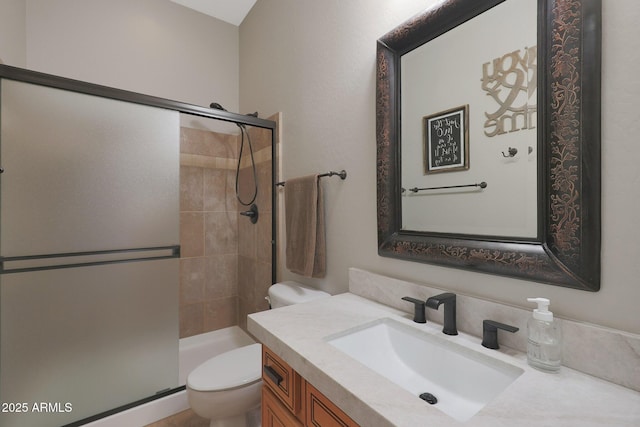 bathroom with toilet, a stall shower, and vanity