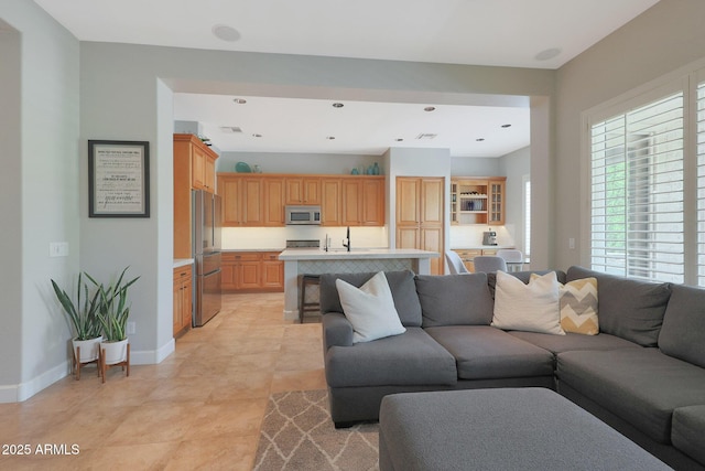 living room featuring baseboards, light tile patterned flooring, and recessed lighting