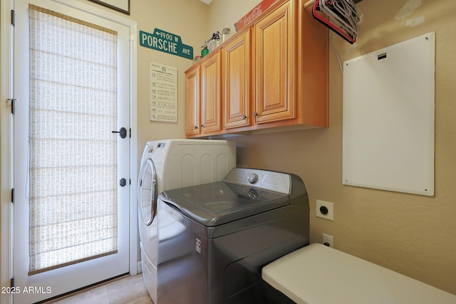 laundry area featuring cabinet space, separate washer and dryer, and light tile patterned floors