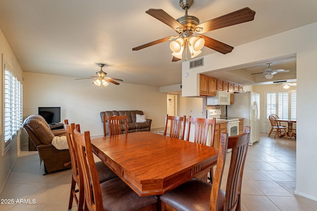dining space featuring light tile patterned flooring and ceiling fan