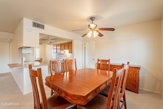 dining space featuring ceiling fan, sink, and light tile patterned floors