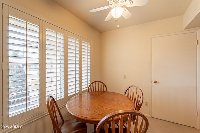 tiled dining space with ceiling fan