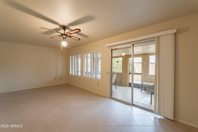 tiled spare room with ceiling fan