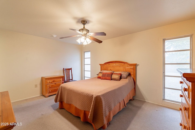 carpeted bedroom featuring ceiling fan and multiple windows