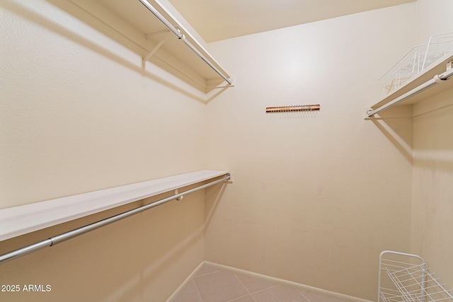 walk in closet with tile patterned floors