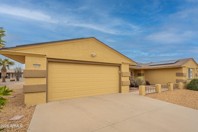 ranch-style house featuring a garage and solar panels