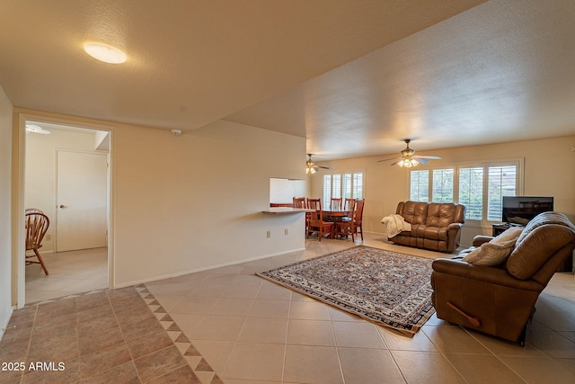 living room featuring light tile patterned floors, a textured ceiling, and ceiling fan