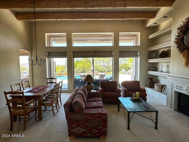 carpeted living room with beam ceiling, plenty of natural light, and built in features