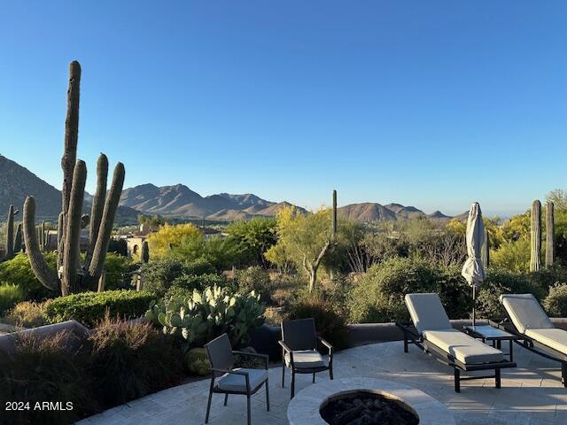 view of patio with a mountain view and a fire pit