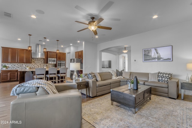 living room with ceiling fan and light hardwood / wood-style flooring