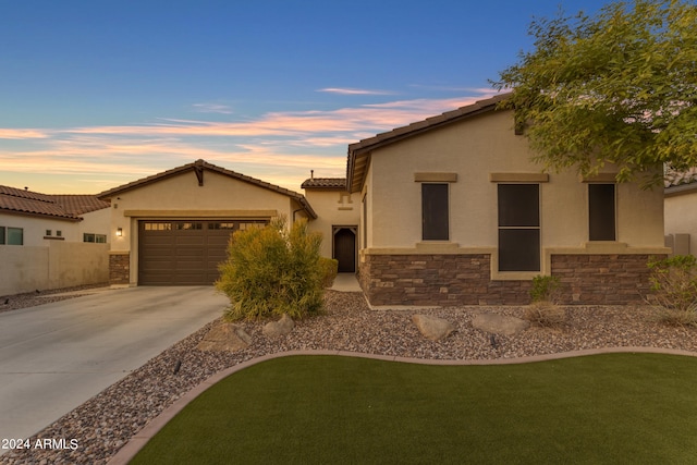 mediterranean / spanish-style home with a lawn and a garage