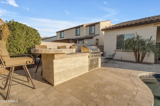 view of patio with an outdoor kitchen and grilling area