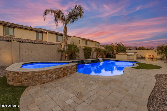 pool at dusk with a patio, pool water feature, and an in ground hot tub