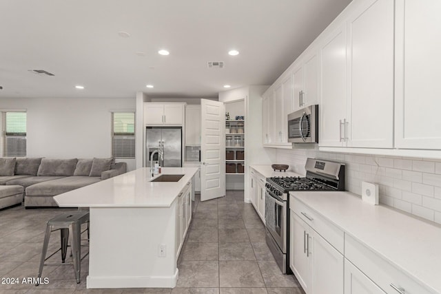 kitchen with appliances with stainless steel finishes, white cabinetry, and sink