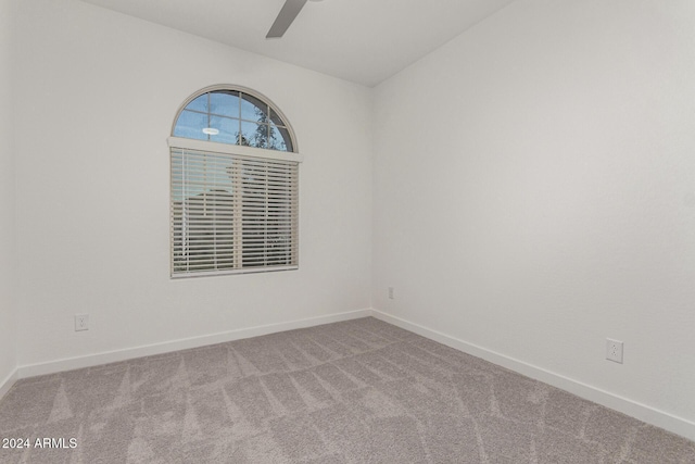 empty room featuring ceiling fan and light colored carpet