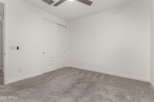 unfurnished bedroom with carpet, a closet, and ceiling fan