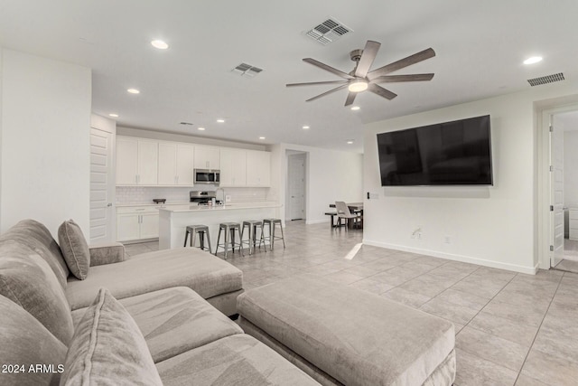 tiled living room featuring ceiling fan