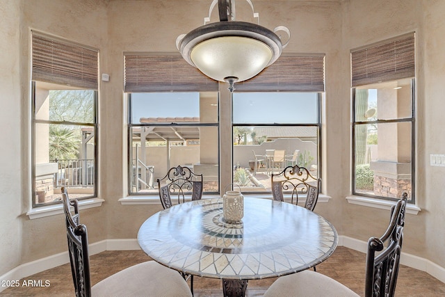 dining area featuring a textured wall and baseboards