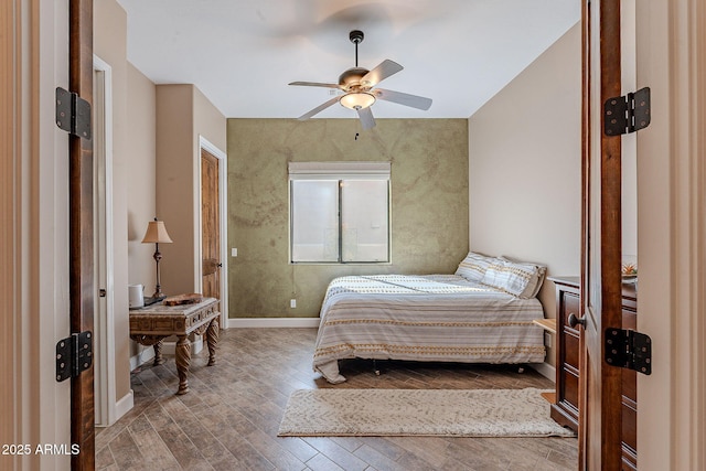 bedroom featuring ceiling fan, baseboards, and wood finished floors