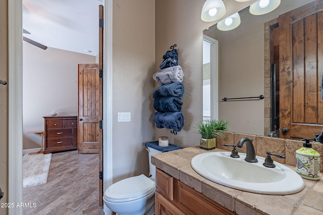 bathroom featuring toilet, wood finished floors, and vanity