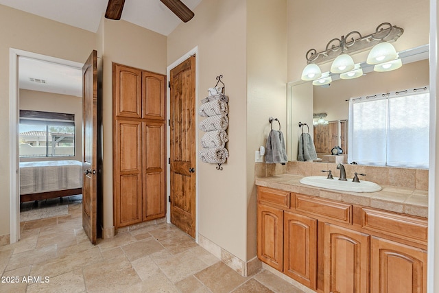 bathroom featuring a wealth of natural light, visible vents, vanity, and stone tile floors